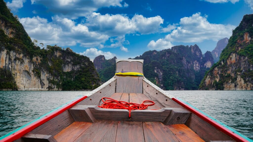 A peaceful boat ride through the scenic limestone cliffs of Khao Sok National Park, Thailand.